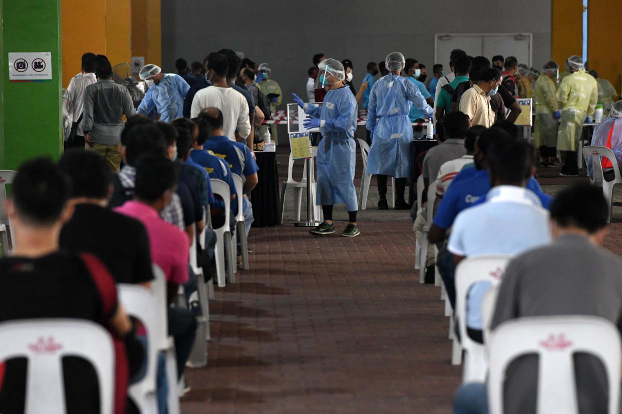 Essential workers wait to take nasal swab tests to detect the COVID-19 novel coronavirus before returning to work in Singapore on June 10, 2020. (Photo by Roslan RAHMAN / AFP) (Photo by ROSLAN RAHMAN/AFP via Getty Images)