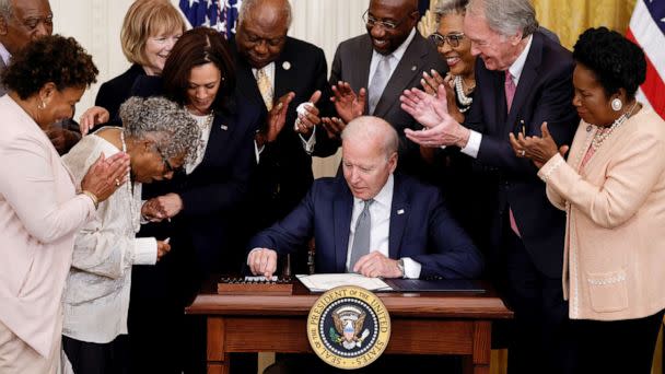 PHOTO: President Joe Biden is applauded as he reaches for a pen to sign the Juneteenth National Independence Day Act into law as Vice President Kamala Harris stands by in the East Room of the White House June 17, 2021.  (Carlos Barria/Reuters)