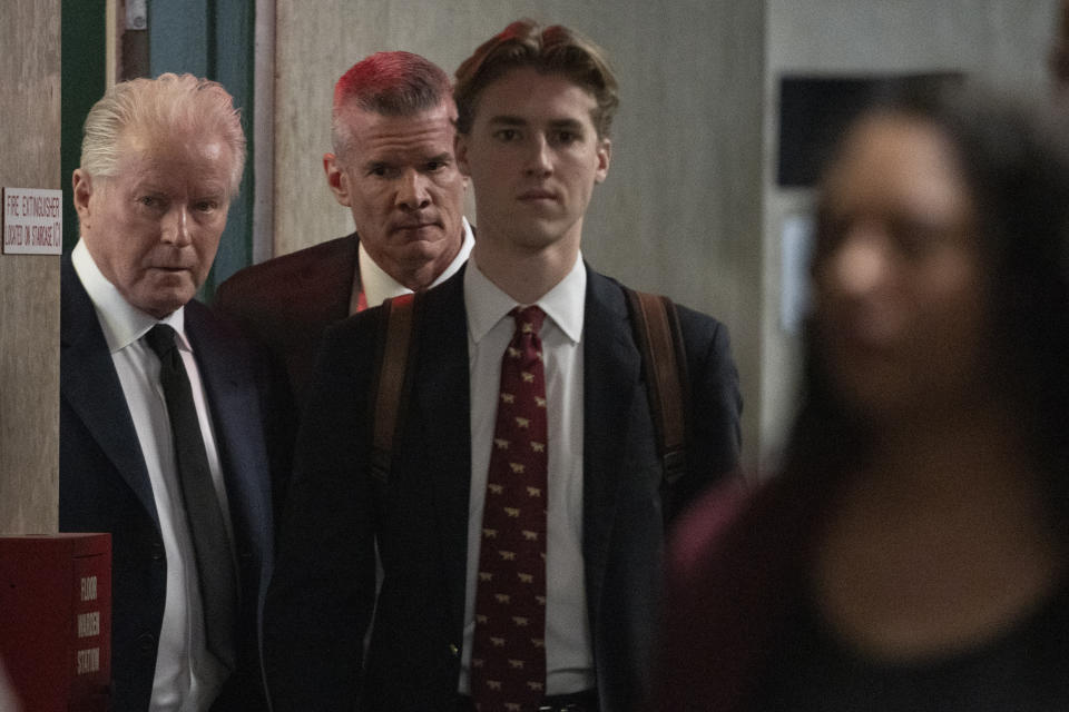 Musician Don Henley, left, surrounded by security, arrives at Supreme Court to testify, Monday, Feb. 26, 2024, in New York. The trial surrounding pages of draft lyrics to "Hotel California" and other Eagles hits is set to feature a star witness: Don Henley. The Eagles co-founder is scheduled to testify Monday at the criminal trial of three collectibles professionals. (AP Photo/Mary Altaffer)