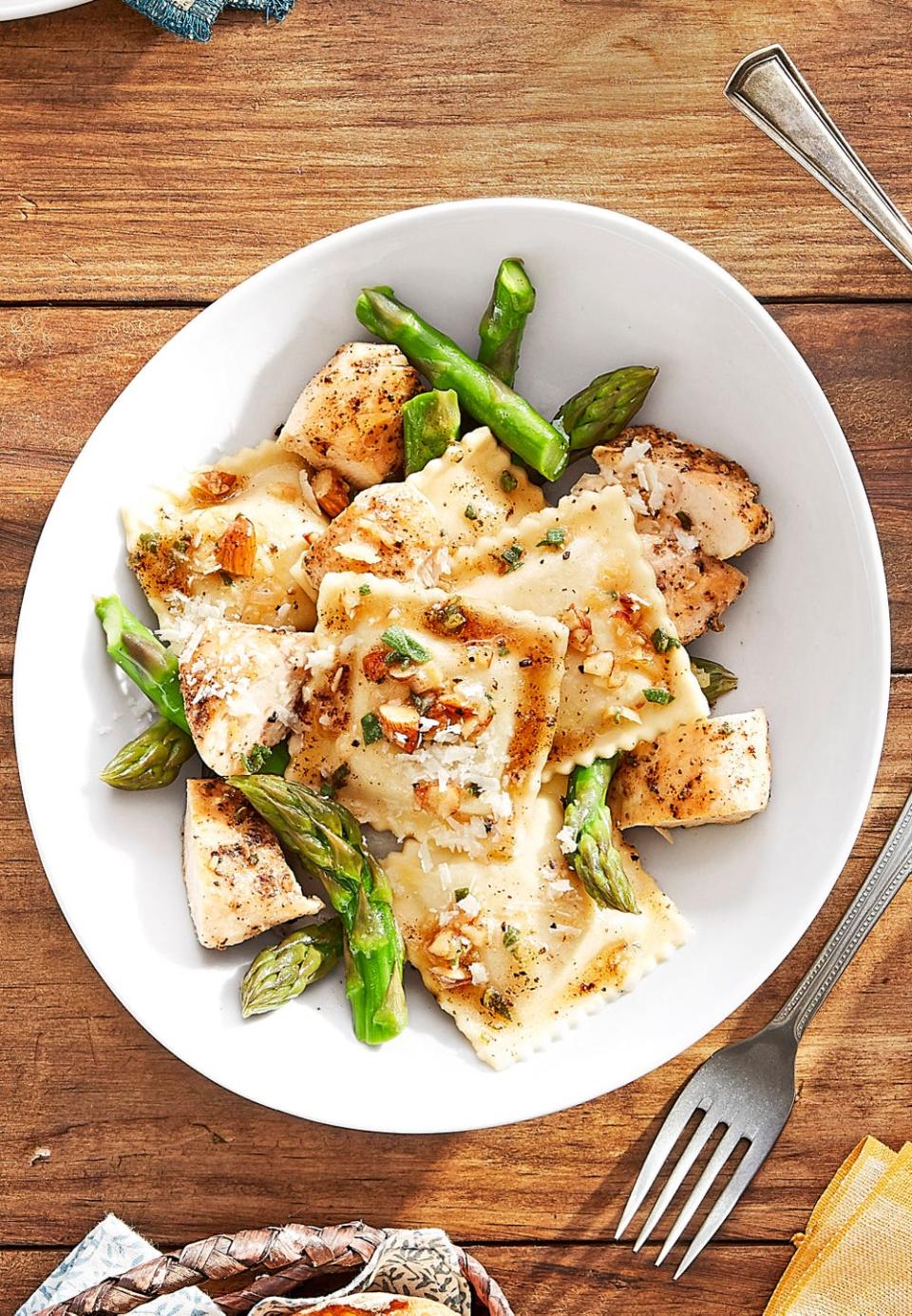 butternut squash ravioli with seared chicken in a bowl with asparagus