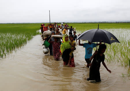 A group of Rohingya refugee people walk in the water after crossing the Bangladesh-Myanmar border in Teknaf, Bangladesh, September 1, 2017. REUTERS/Mohammad Ponir Hossain