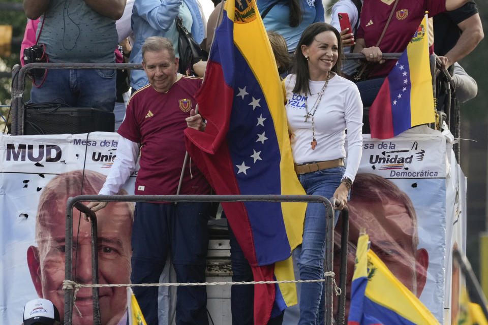 El candidato presidencial de oposición Edmundo González ondea una bandera junto a la líder opositora María Corina Machado en un acto de inicio de la campaña política ante las elecciones presidenciales del 28 de julio en Caracas, Venezuela, el jueves 4 de julio de 2024. (AP Foto/Ariana Cubillos)