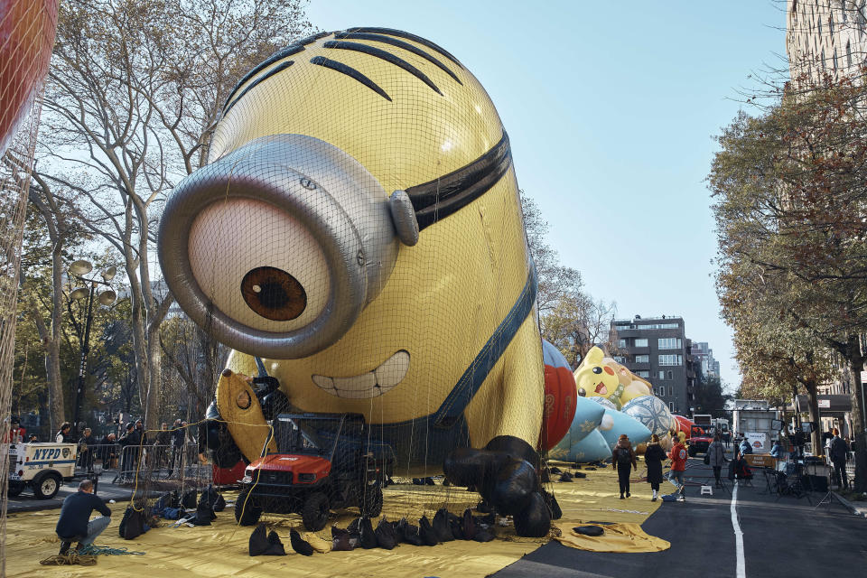 A man takes a photo of an inflated helium balloon of Stuart the Minion on Wednesday, Nov. 23, 2022, in New York, as the balloon is readied for the Macy's Thanksgiving Day Parade on Thursday. (AP Photo/Andres Kudacki)