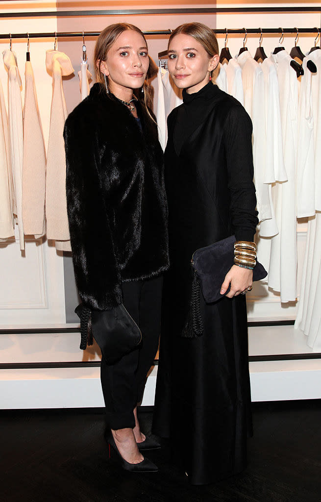 The Olsen sisters standing in front of racks of clothing