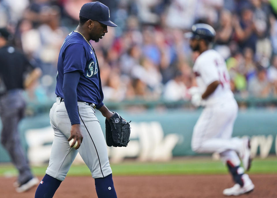 Seattle Mariners starting pitcher Justin Dunn, left, waits for Cleveland Indians' Bobby Bradley to run the bases after Bradley hit a solo home run during the third inning of a baseball game Friday, June 11, 2021, in Cleveland. (AP Photo/Tony Dejak)