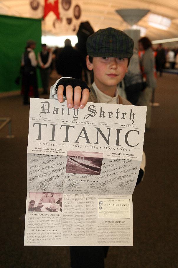 A child poses with a memorial newspaper in the departure lounge of the MS Balmoral cruise ship