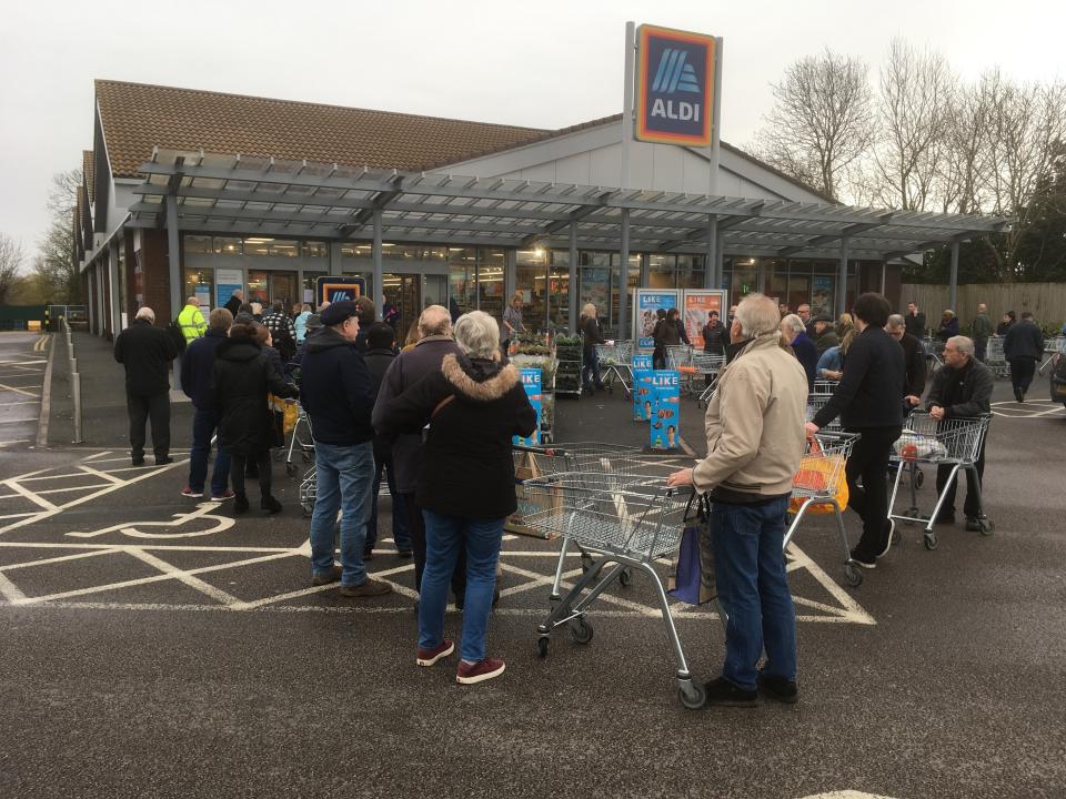 Early shoppers queue and wait in line for the opening of a supermarket in Rugby, England, Thursday, March 19, 2020. According to the World Health Organization, most people recover in about two to six weeks, depending on the severity of the illness. Some supermarkets are limiting the number of similar items shopper can buy to try and halt hoarding and panic buying, when the supermarket groups and government say there is no shortages in the supply chain. (AP Photo/Martin Cleaver)