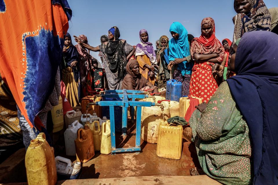 Displaced women gather around a water distribution area in Doolow. (Giles Clarke)