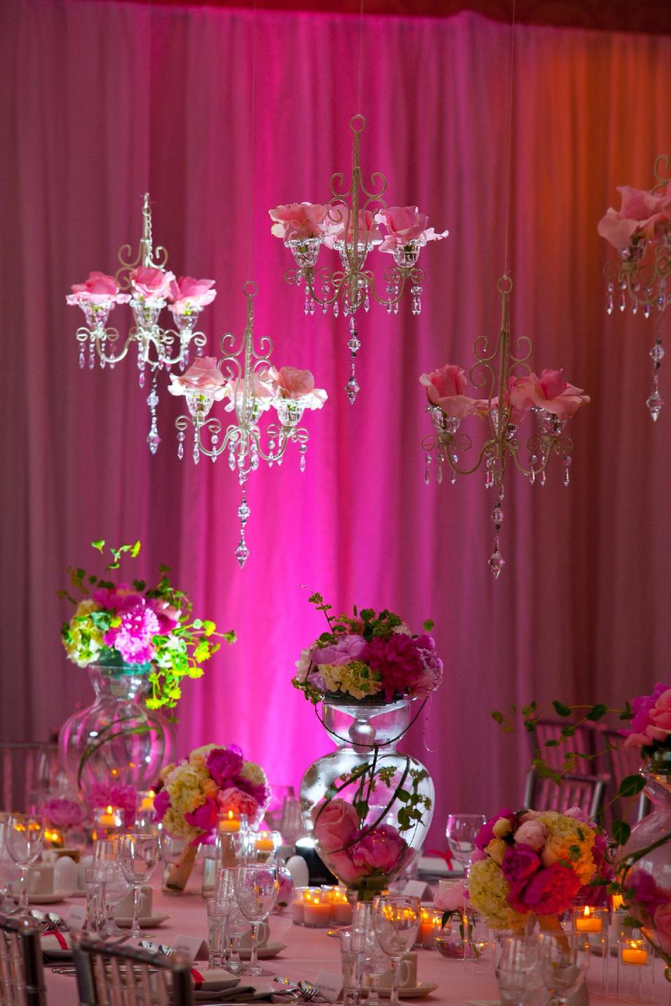 This publicity photo provided by Prince George Hotel shows tall vessels, with submerged flower blooms that set a dramatic table at this late spring wedding with a romantic evening theme. After a period of unpopularity, wedding reception flowers are back in a big way, says Craig Norton, Director of Operations for Halifax Canada’s Prince George Hotel, which hosts 40 to 50 weddings each year. (AP Photo/Prince George Hotel, Liam Hennessey, Applehead Studio, Inc.)