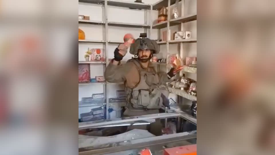 A video posted online shows an Israeli soldier is seen smashing merchandise in a shop in Gaza. - Obtained by CNN