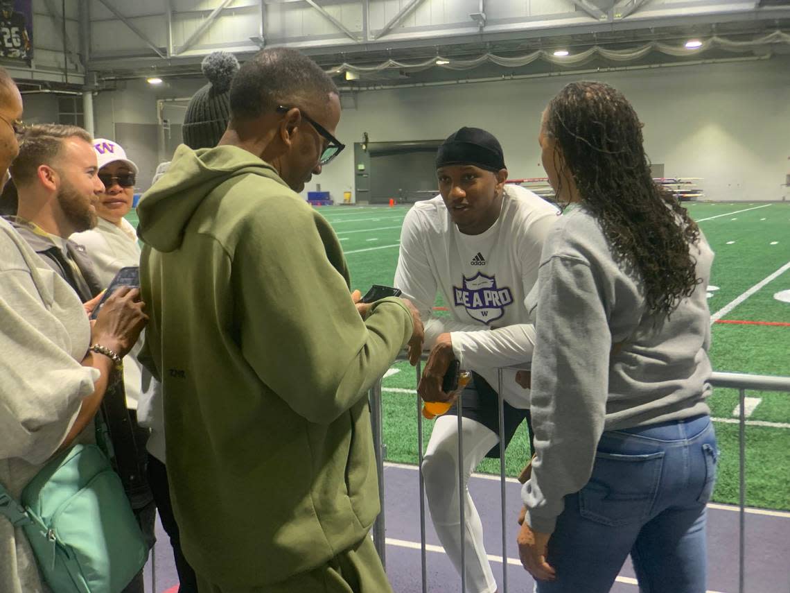 Quarterback Michael Penix Jr. talks with his family on the sidelines at his Pro Day workout for Seahawks general manager John Schneider and personnel from at least 30 of the 32 NFL teams at the University of Washington’s Dempsey Indoor facility March 28, 2024.