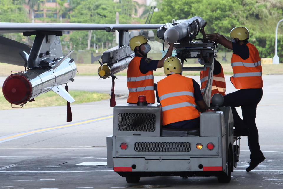 Military personnel load a AIM-120 advanced medium range air-to-air missile next to a AIM-9 and a Harpoon A-84, anti-ship missile on a F16V fighter jet at the Hualien Airbase in Taiwan's southeastern Hualien county on Wednesday, Aug. 17, 2022. Taiwan is staging military exercises to show its ability to resist Chinese pressure to accept Beijing's political control over the island. (AP Photo/Johnson Lai)