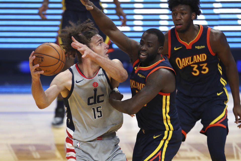 Washington Wizards center Robin Lopez, left, looks for a shot against Golden State Warriors forward Draymond Green during the first half of an NBA basketball game in San Francisco, Friday, April 9, 2021. (AP Photo/Jed Jacobsohn)