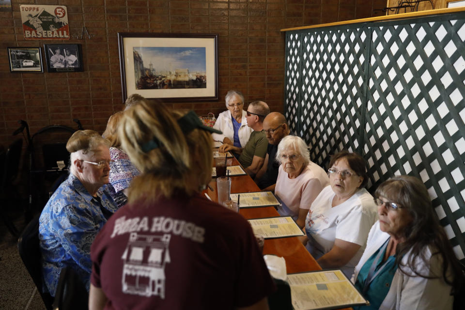 Local residents listen as a waitress takes their order at the Pizza House restaurant one of the oldest restaurants in Galesburg, Ill., Wednesday, June 16, 2021. (AP Photo/Shafkat Anowar)