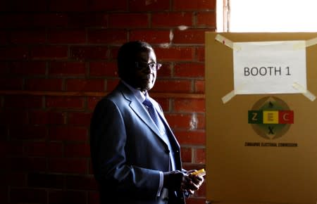 FILE PHOTO: Zimbabwe's President Mugabe looks on before casting his vote in Highfields