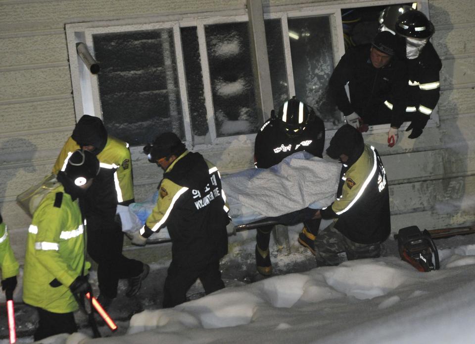 Rescue workers carry a body of a university student trapped by debris from the collapsed resort in Gyeongju