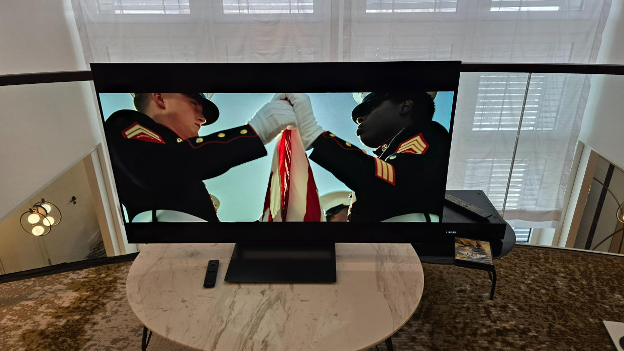  Samsung S90D 48-inch TV on a marble table with Top Gun Maverick playing on screen . 