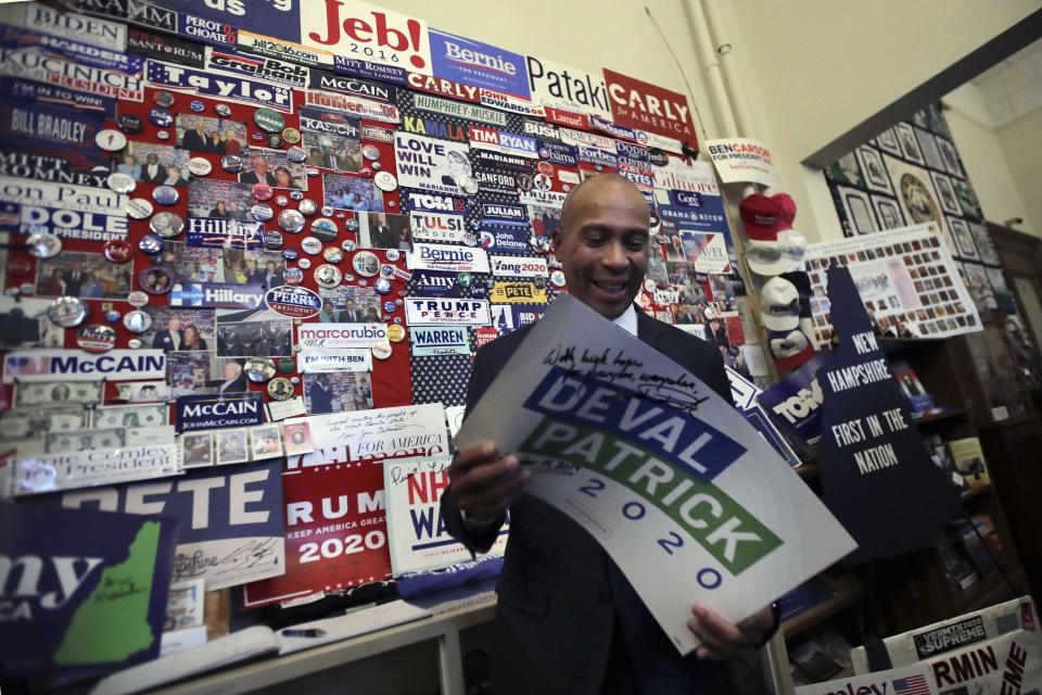 Former Massachusetts Gov. Deval Patrick adds his campaign sign to pins, signs and bumper stickers of New Hampshire primary presidential contenders on display in the State House visitors’ center on Nov. 14 in Concord, N.H. (Photo: Charles Krupa/AP)