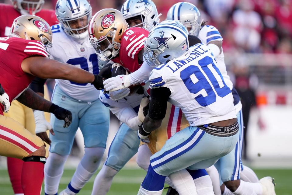 Dallas Cowboys defensive end DeMarcus Lawrence (90) tackles San Francisco 49ers wide receiver Deebo Samuel (19) during the first quarter of a NFC divisional round game at Levi's Stadium.