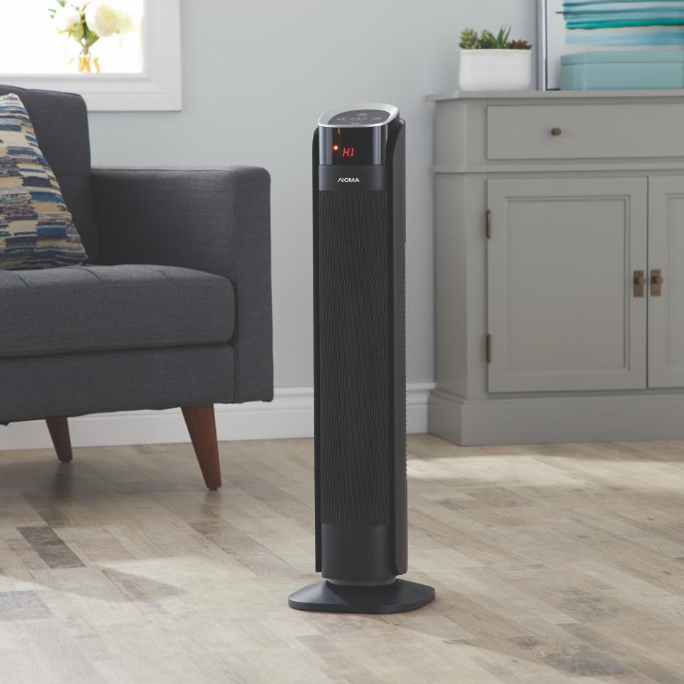 A NOMA standing portable heater from Canadian Tire sits alone on the floor in a living room