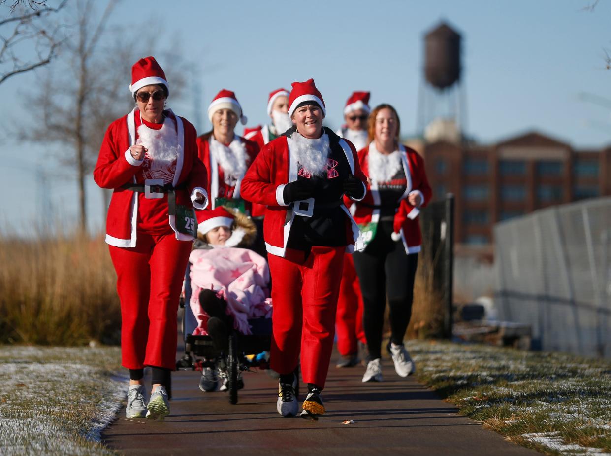 Three hundred runners donned their Santa robes and caps and hit the streets of downtown Des Moines during the Fleet Feet Santa Run 5K running event on Saturday, Dec. 11, 2021.