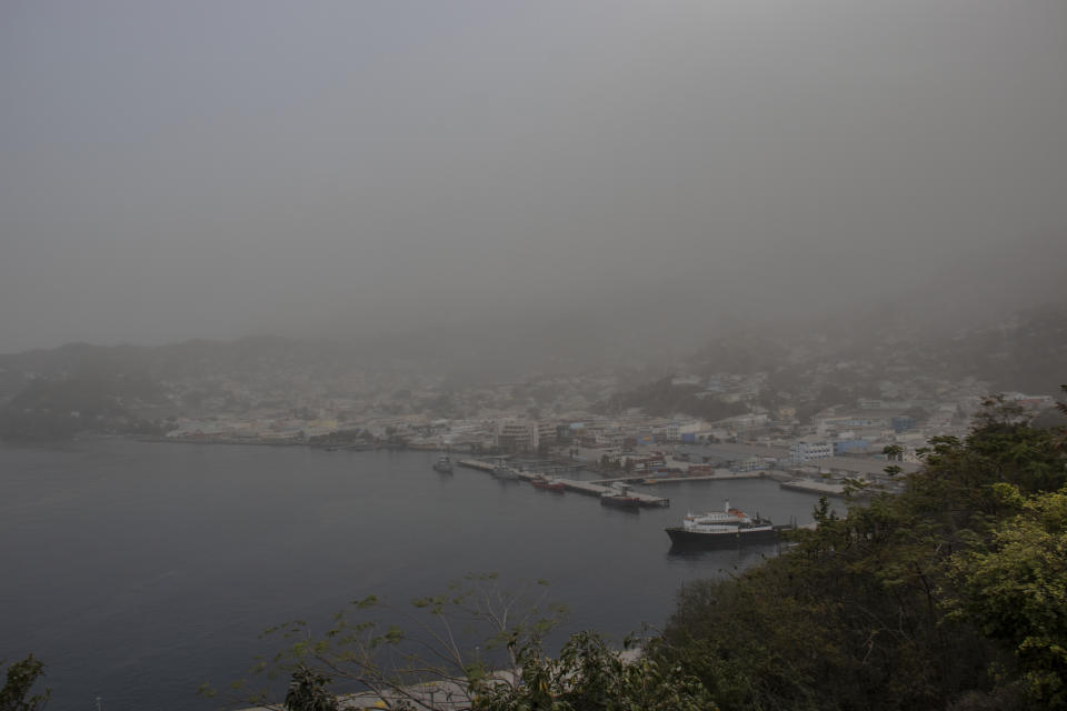 A cloud of volcanic ash hovers over Kingstown, on the eastern Caribbean island of St. Vincent, Saturday, April 10, 2021, a day after the La Soufriere volcano erupted. (AP Photo/Lucanus Ollivierre)