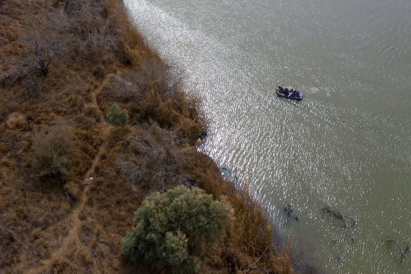 Smugglers use raft to transport migrant families and children into the United States from Mexico in Penitas, Texas