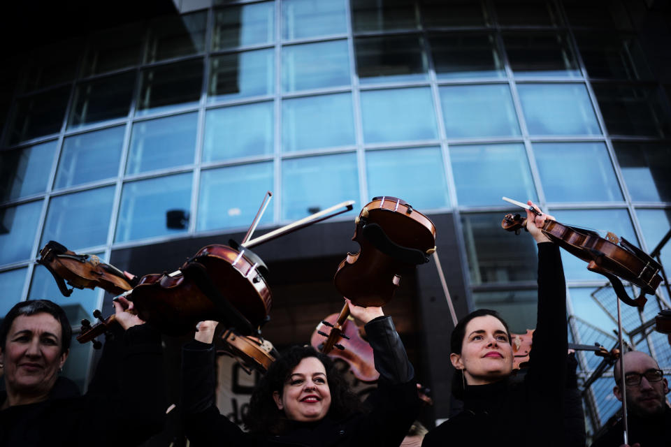 Striking musicians of the Paris Opera house hold their violins after performing outside the Bastille Opera house Tuesday, Dec. 31, 2019 in Paris. (AP Photo/Kamil Zihnioglu)