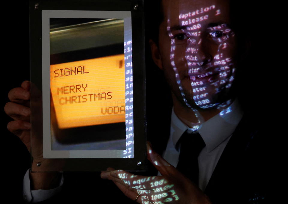 Aguttes auction house head of development Maximilien Aguttes holds a non-fungible token (NFT), replica of the original communication protocol that transmitted the first SMS text message ever sent, before its auction by Britain's Vodafone, in Neuilly-sur-Seine, near Paris, France, December 20, 2021.  REUTERS/Christian Hartmann
