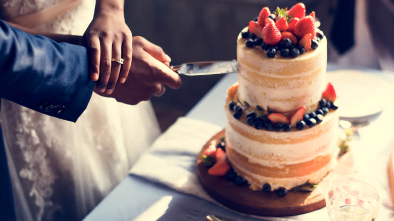 Bride and groom cutting wedding cake