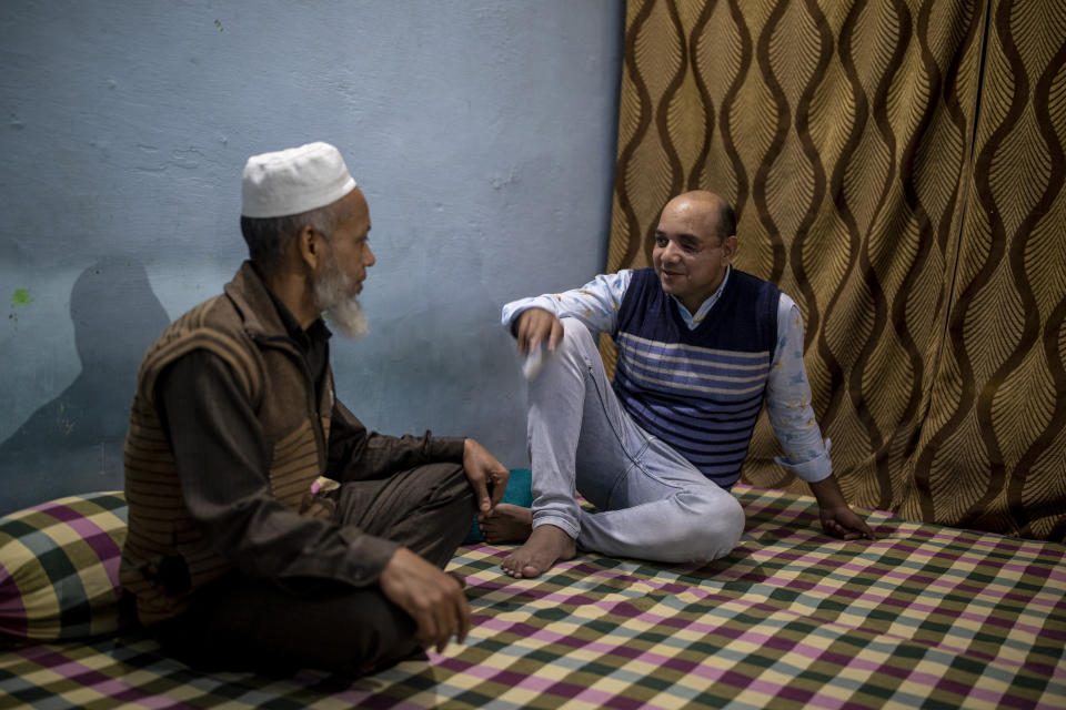 Muhammad Nasir Khan, right,who was shot by a Hindu mob during the February 2020 communal riots, speaks to his father Abdul Jaleel inside his home in North Ghonda, one of the worst riot affected neighborhood, in New Delhi, India, Friday, Feb. 19, 2021. As the first anniversary of bloody communal riots that convulsed the Indian capital approaches, Muslim victims are still shaken and struggling to make sense of their struggle to seek justice. (AP Photo/Altaf Qadri)