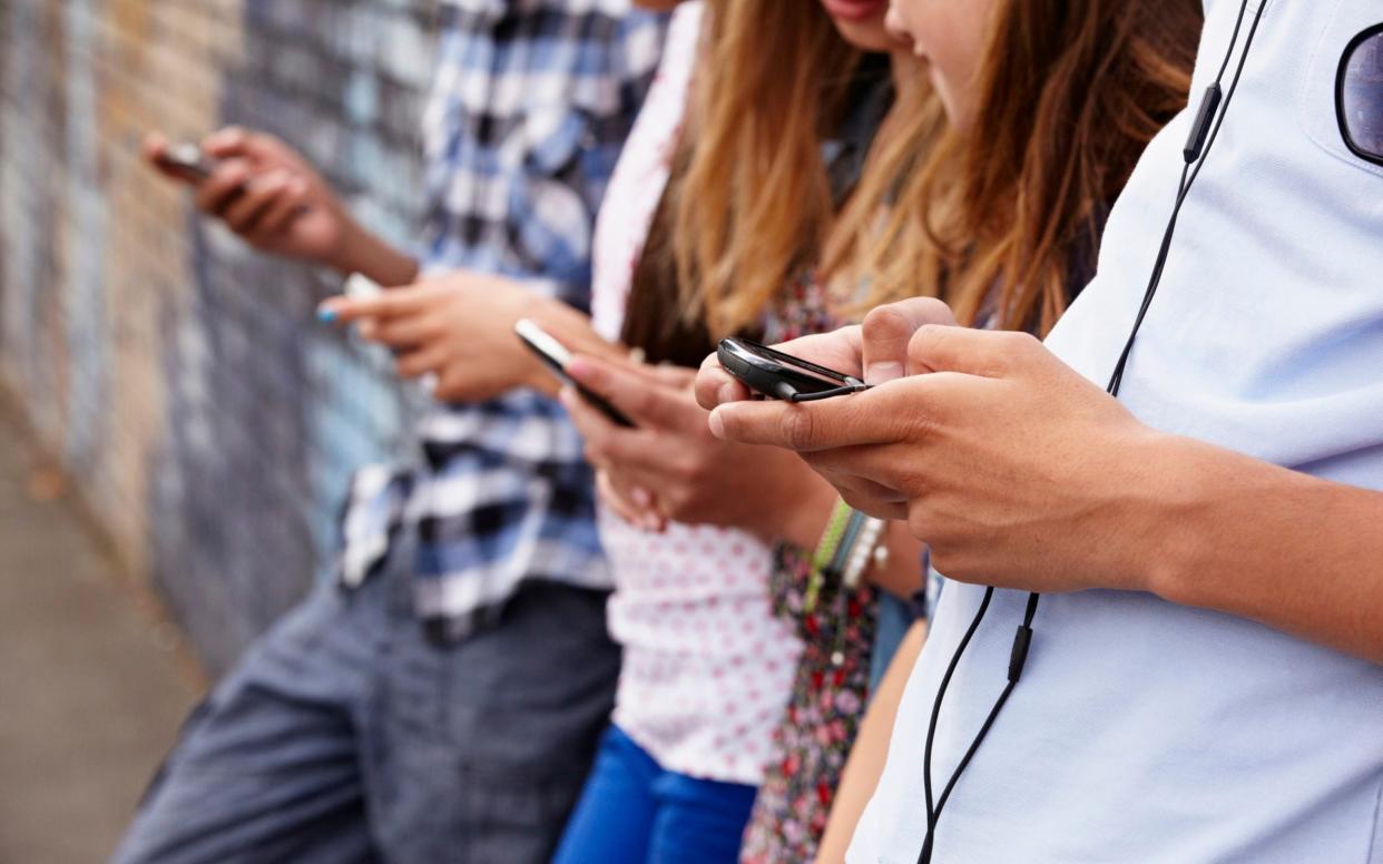 Teenagers using cellphones -  Image Source