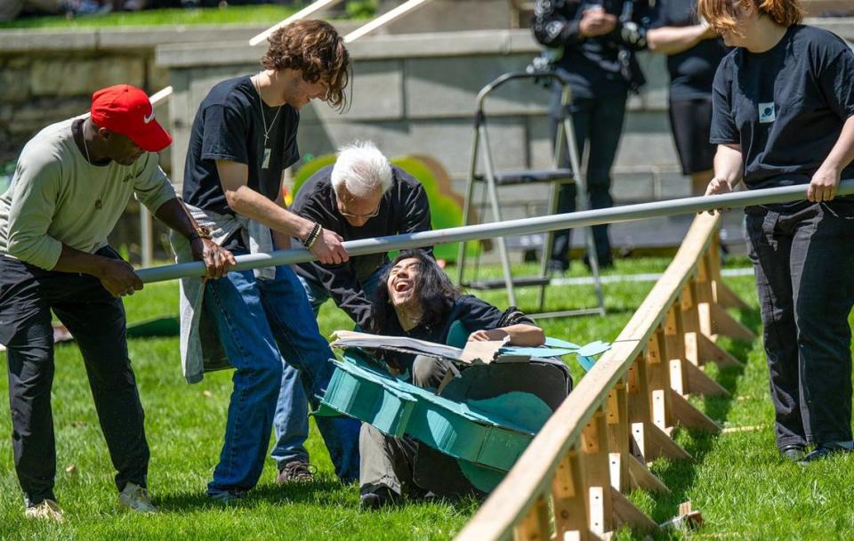 As his cardboard dragon collapses, sophomore IBen Reyes, 19, of Kansas City tumbles to the grass at Rail Day.