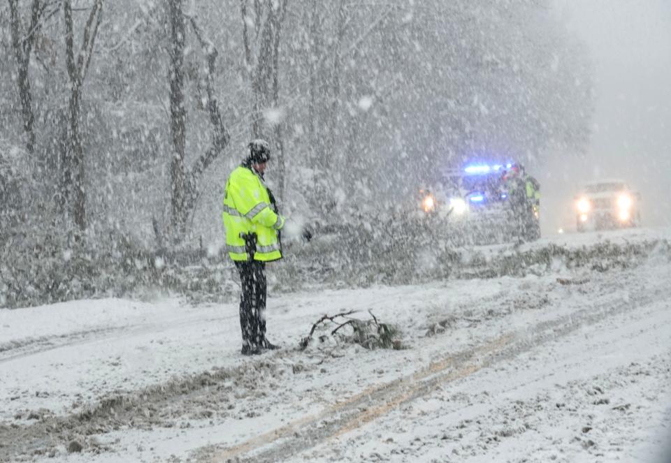 Barnstable police direct traffic after a large branch fell across Route 28 in Marstons Mills Tuesday afternoon. Traffic was backed up while it was removed in the heavy snow.
