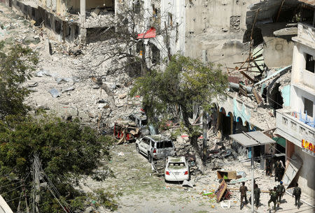 Security personal are seen next to buildings damaged at the scene where a suicide car bomb exploded targeting a Mogadishu hotel in a business center in Maka Al Mukaram street in Mogadishu, Somalia March 1, 2019. REUTERS/Feisal Omar