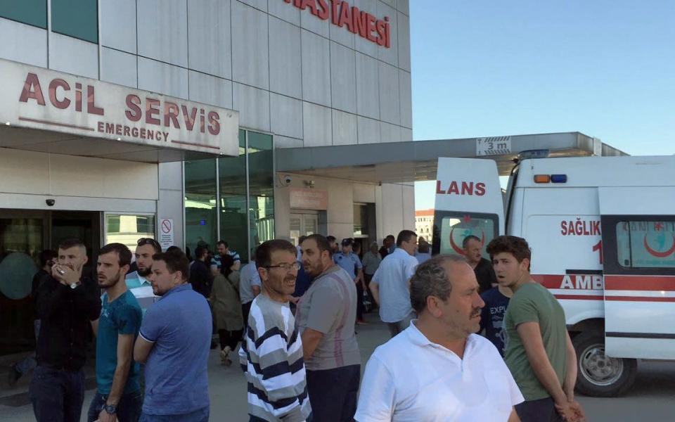 People wait outside a hospital in western Turkey  - Credit: IHA via AP