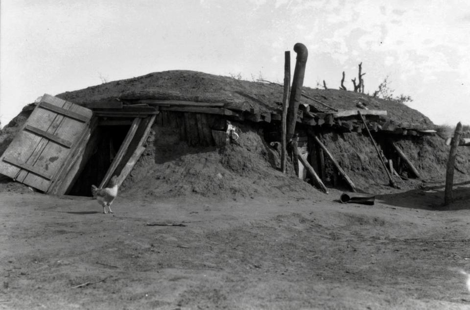 A sharecropper's home in Oklahoma is pictured during the early 1900s. Sharecroppers and tenant farmers were subjected to very poor conditions and often lived in "dugout" style dirt homes.