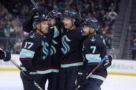 Seattle Kraken defenseman Adam Larsson, second from right is congratulated after scoring by right wing Jordan Eberle (7), defenseman Justin Schultz, second from left, and center Jaden Schwartz (17) during the first period of an NHL hockey game against the San Jose Sharks, Thursday, April 11, 2024, in Seattle. (AP Photo/John Froschauer)