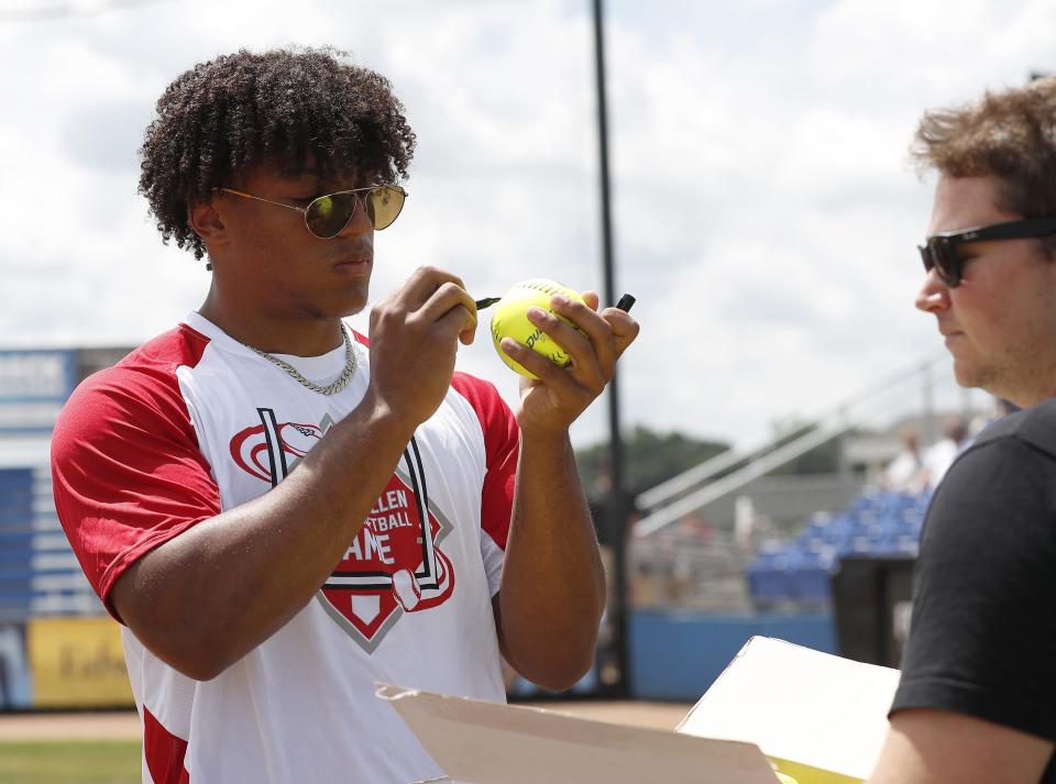 Wisconsin Badgers running back and Fond du Lac native Braelon Allen autographs softballs before the start of the Braelon Allen Charity Softball Game July 17, 2022, in Fond du Lac, Wis.