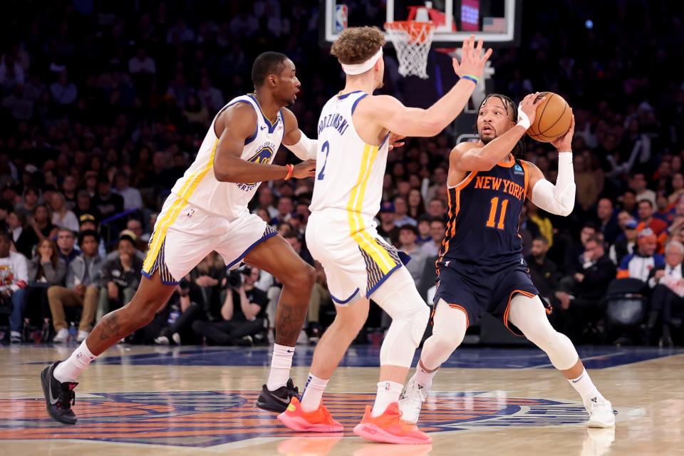 Feb 29, 2024; New York, New York, USA; New York Knicks guard Jalen Brunson (11) controls the ball against Golden State Warriors forward Jonathan Kuminga (00) and guard Brandin Podziemski (2) during the first quarter at Madison Square Garden. Mandatory Credit: Brad Penner-USA TODAY Sports