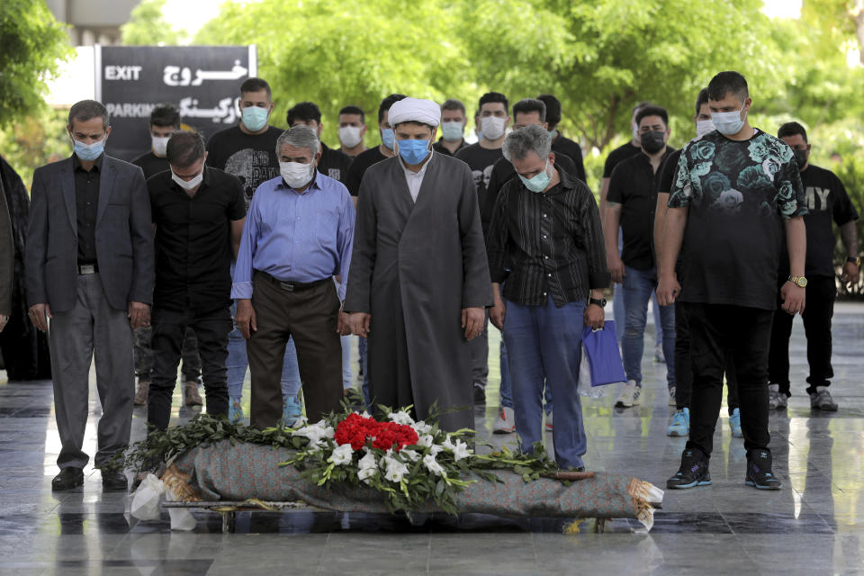 Mourners pray over the body of a person who died from COVID-19, at the Behesht-e-Zahra cemetery just outside Tehran, Iran, Wednesday, April 21, 2021. After facing criticism for downplaying the virus last year, authorities have put partial lockdowns and other measures in place to try and slow the coronavirus’ spread, as Iran faces what looks like its worst wave of the coronavirus pandemic yet. (AP Photo/Ebrahim Noroozi)