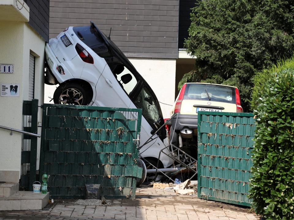 A white car sits damaged in someone's driveway after severe flooding swept Germany.