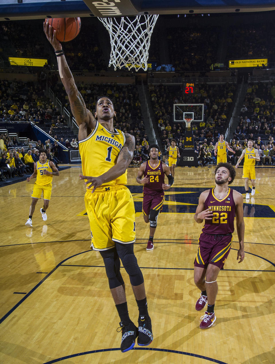 Michigan guard Charles Matthews (1) breaks away for a basket, followed by Minnesota guard Gabe Kalscheur (22), in the first half of an NCAA college basketball game at Crisler Center in Ann Arbor, Mich., Tuesday, Jan. 22, 2019. (AP Photo/Tony Ding)