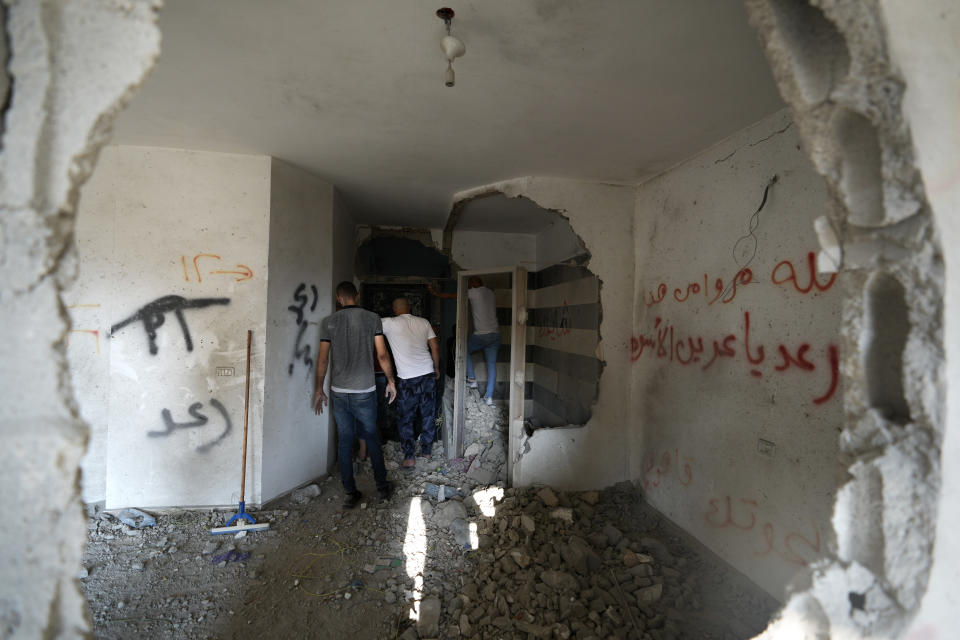 People look at the demolished house of Palestinian gunman Raed Hazem, who carried out a deadly attack in Tel Aviv in April, after it was destroyed by Israeli forces in the West Bank city of Jenin, Tuesday, Sept. 6, 2022. Hazem opened fire into a crowded bar in central Tel Aviv, killing three Israelis and wounding several others. Hours later he was killed in a shootout with Israeli security forces. (AP Photo/Majdi Mohammed)