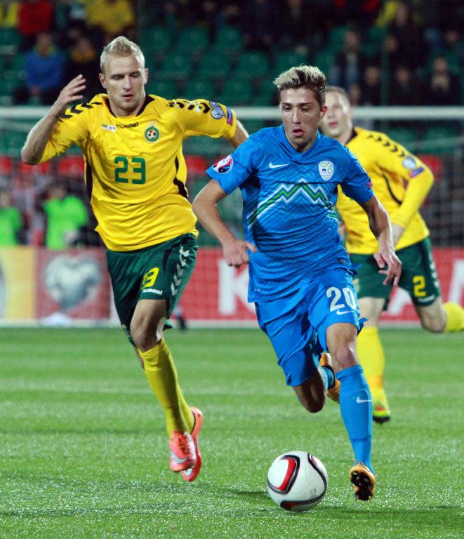 Slovenia's Kevin Kampl (R) and Lithuania's Vytautas Andriuskevicius fight for the ball during their Euro 2016 Group E qualifying football match, in Vilnius, on October 12, 2014