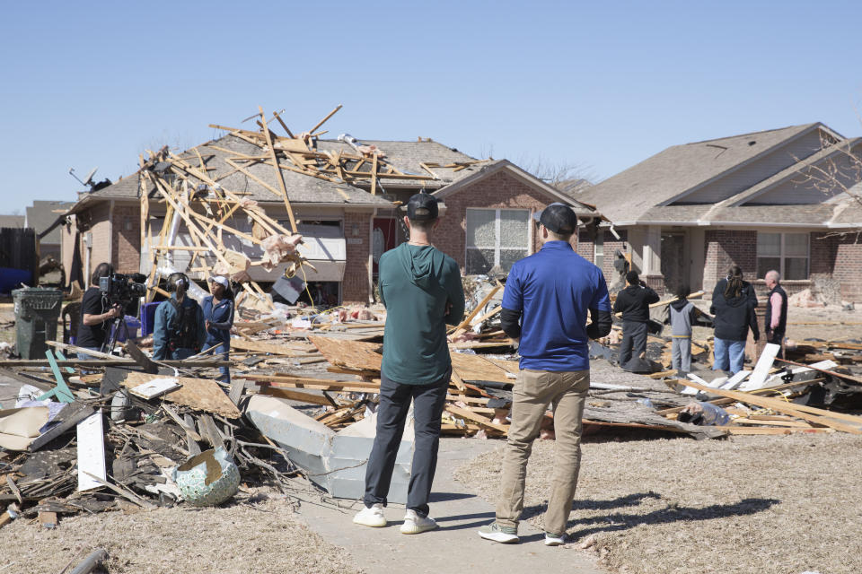 Neighbors look at damage to homes along Frost Lane on Monday, Feb. 27, 2023 in Norman, Okla. The damage came after rare severe storms and tornadoes moved through Oklahoma overnight. (AP Photo/Alonzo Adams)