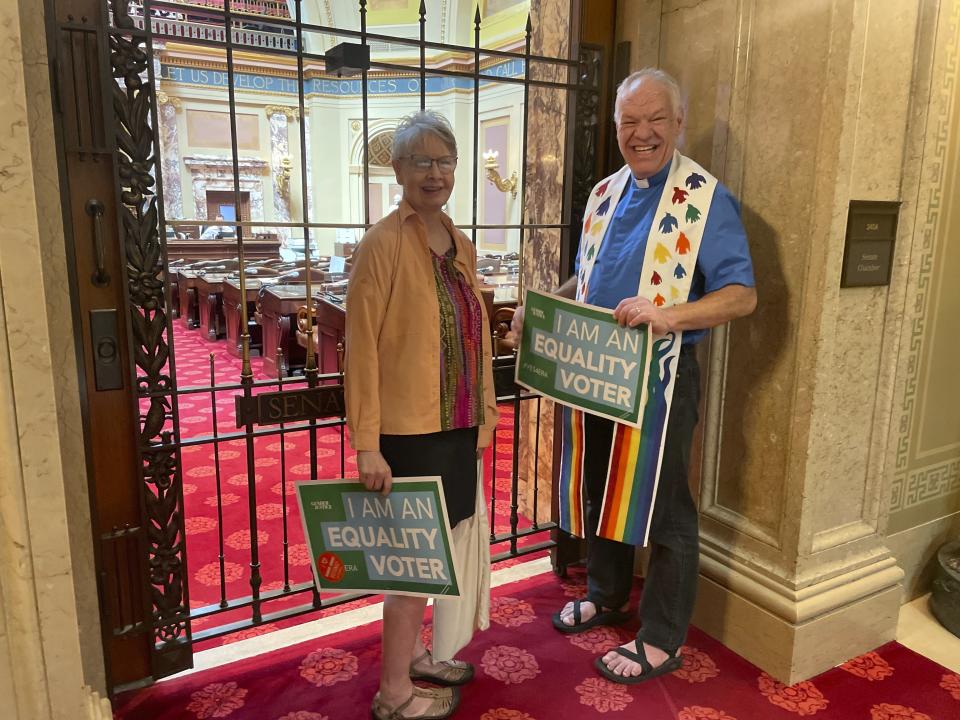 Doug Donley, pastor of University Baptist Church in Minneapolis, wore rainbow colors and held a green sign that said "I am an equality voter" in support of the Minnesota Equal Rights Amendment legislation with his sister, Trish Donley, on Monday, May 13, 2024, in the State Capitol building in St. Paul, Minn., ahead of a House floor vote on the legislation. The amendment would guarantee some of the country's most expansive protections of abortion and LGBTQ+ rights if it is approved by both chambers this session and then by voters in two years. (AP Photo/Trisha Ahmed)