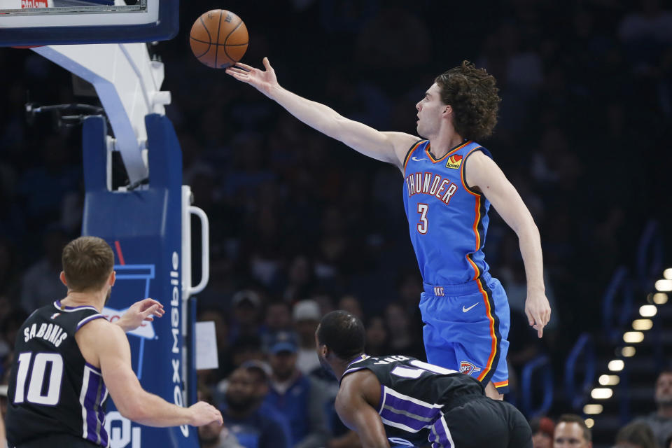 Oklahoma City Thunder guard Josh Giddey (3) shoots as Sacramento Kings forwards Harrison Barnes, lower right, and Domantas Sabonis (10) watch during the first half of an NBA basketball game Tuesday, April 9, 2024, in Oklahoma City. (AP Photo/Nate Billings)