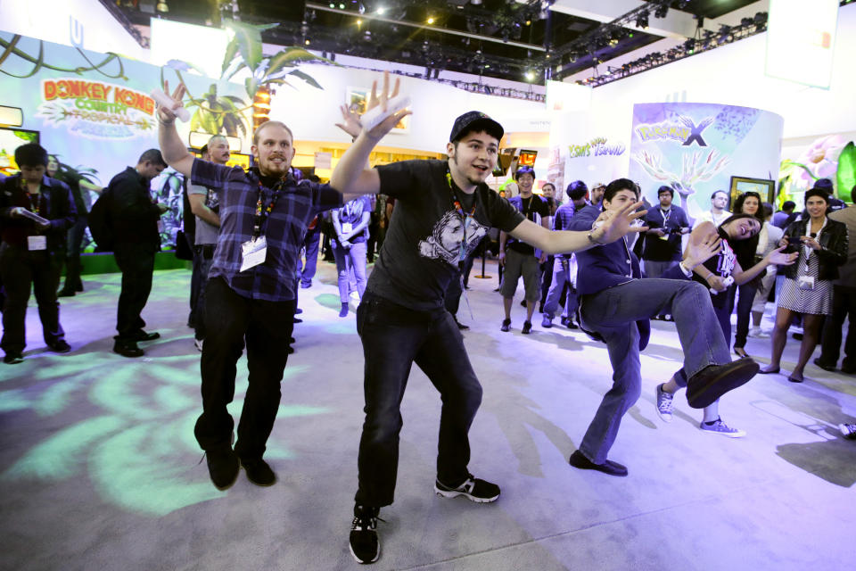 Show attendees Jason Rappaport, from left, Josh Jepson and Rafi Boghos play the video game "Just Dance 2014" at the Nintendo booth during the Electronic Entertainment Expo in Los Angeles, Thursday, June 13, 2013. (AP Photo/Jae C. Hong)