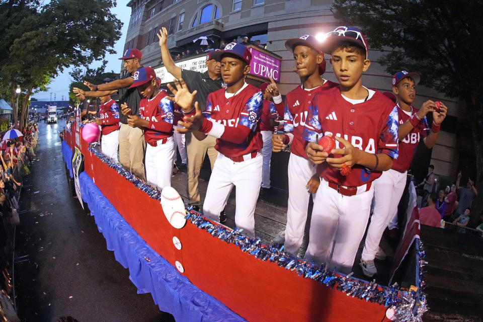 The Cuba Region champion Little League team from Bayamo, Cuba, rides in the Little League Grand Slam Parade in downtown Williamsport, Pa., Monday, Aug. 14, 2023. The Little League World Series baseball tournament, featuring 20 teams from around the world, starts later in week in South Williamsport, Pa. (AP Photo/Gene J. Puskar)